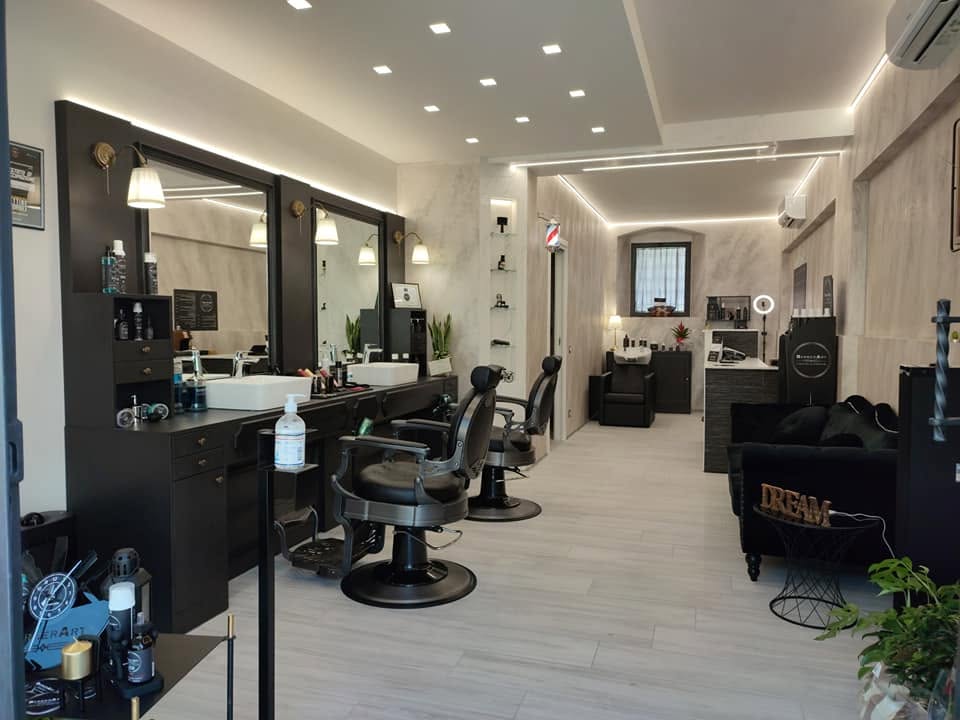 Interno del salone BarberArt: postazioni di taglio, poltrone da barbiere e zona attesa